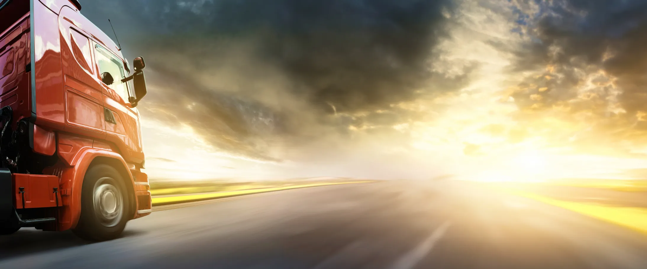 Image of a lorry driving towards a sunset